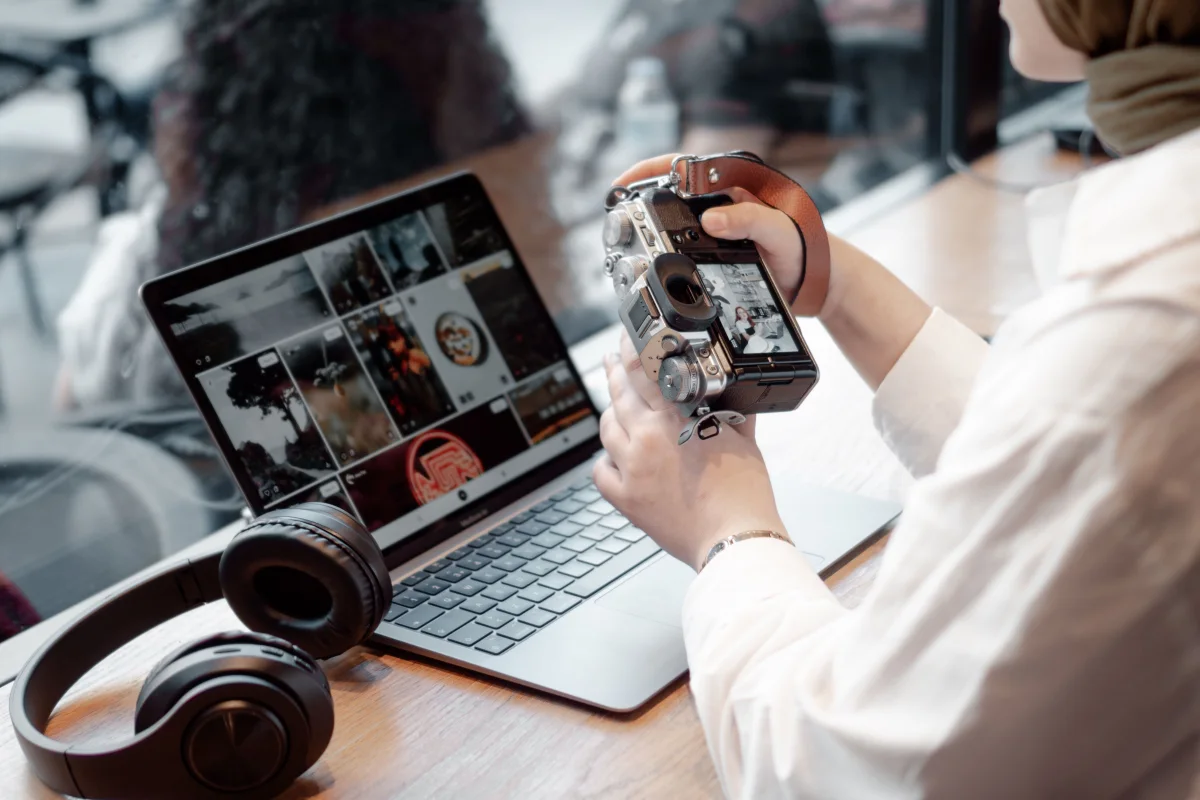 Fotografin sichtet Bilder an Laptop und Kamera