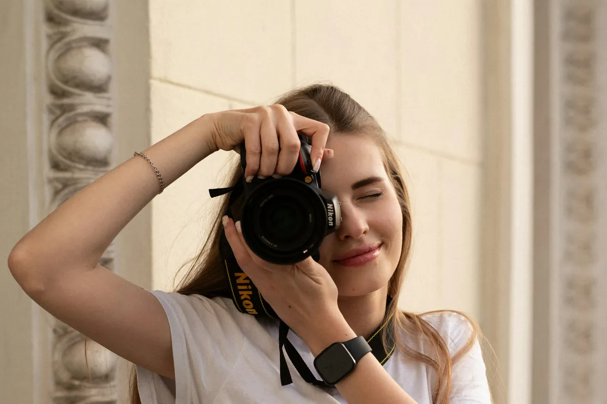 Fotografin mit Spiegelreflexkamera vor dem Gesicht